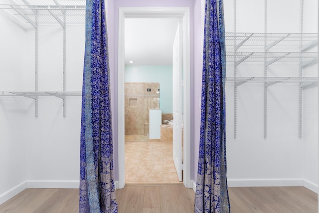 spacious closet featuring light hardwood / wood-style floors