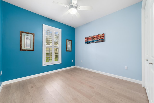 empty room with ceiling fan and light hardwood / wood-style flooring