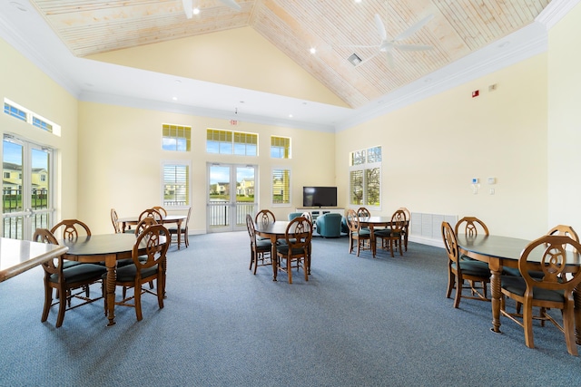 dining area featuring ceiling fan, carpet, a towering ceiling, french doors, and crown molding