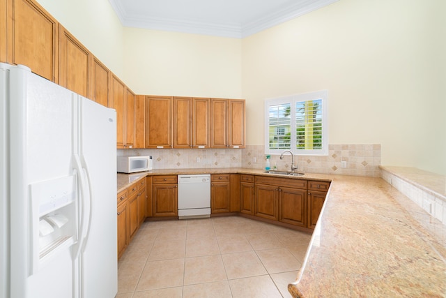 kitchen featuring a high ceiling, white appliances, decorative backsplash, sink, and light tile patterned floors