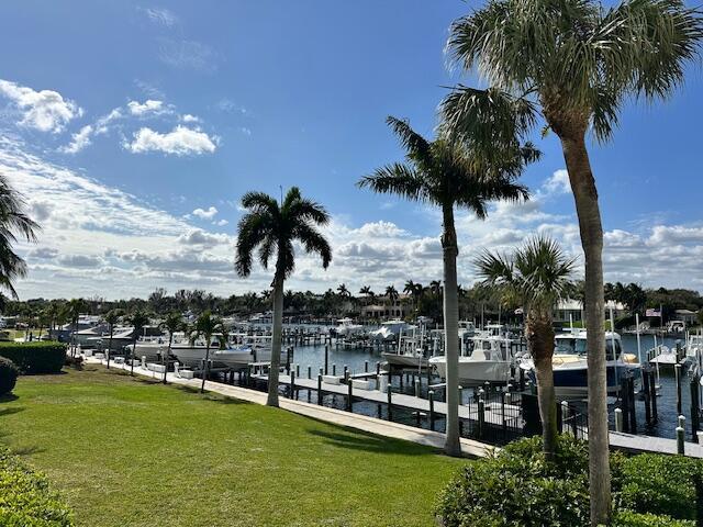 view of dock featuring a water view and a yard