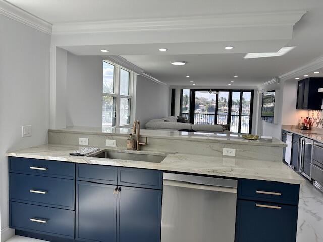 kitchen with light stone counters, open floor plan, a sink, and stainless steel dishwasher