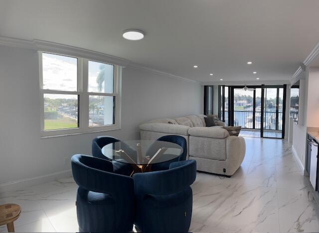 living room with marble finish floor, ornamental molding, recessed lighting, and baseboards