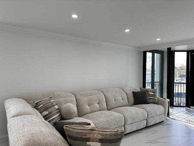 living room with ornamental molding, recessed lighting, and marble finish floor