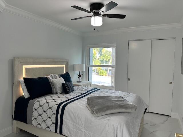 bedroom featuring marble finish floor, crown molding, and baseboards