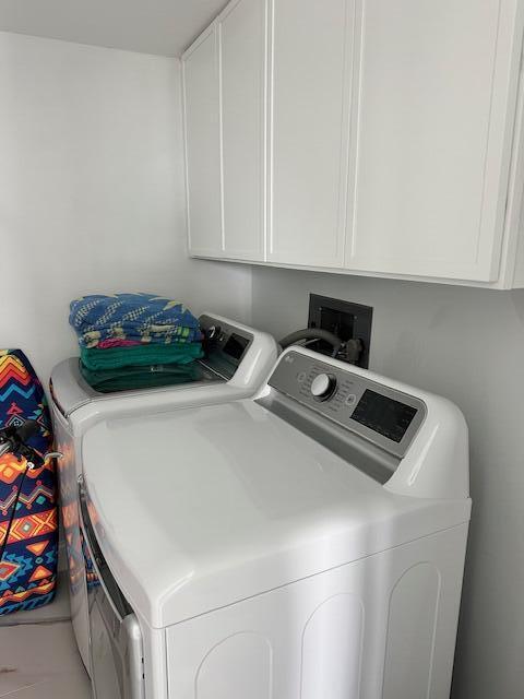 washroom with cabinet space and washing machine and dryer