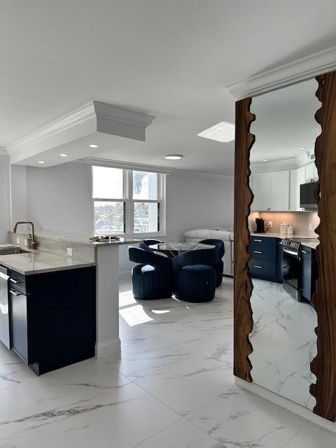 kitchen featuring marble finish floor, ornamental molding, white cabinets, a sink, and range with electric cooktop