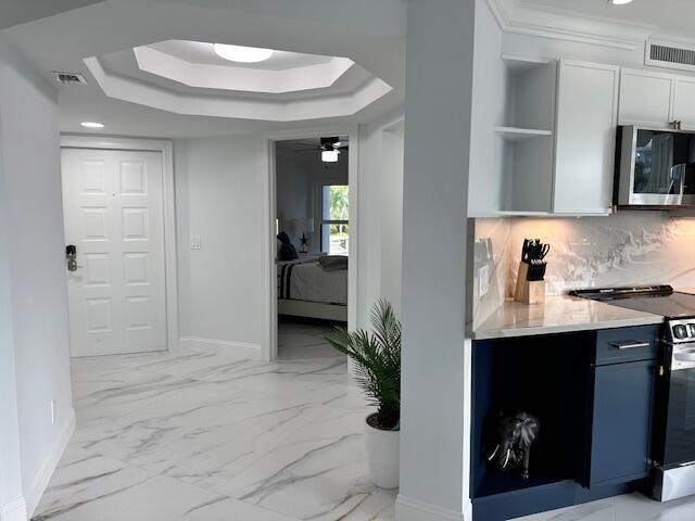 kitchen with white cabinets, electric range oven, stainless steel microwave, light countertops, and open shelves