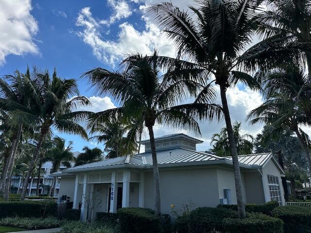 view of property exterior with metal roof, a standing seam roof, and stucco siding