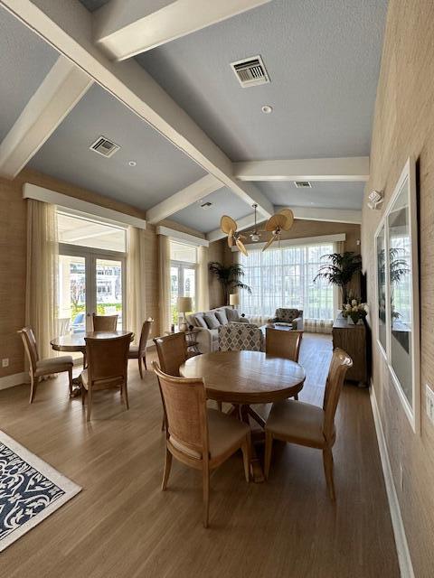 dining room featuring french doors, wood finished floors, visible vents, and a healthy amount of sunlight