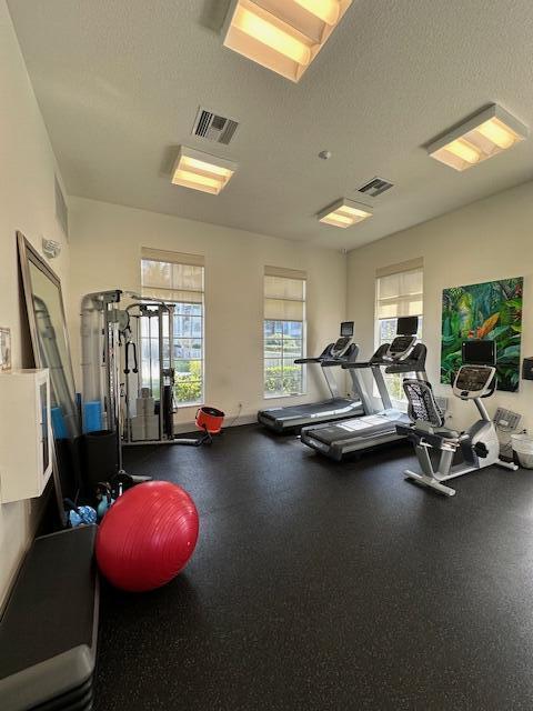 gym with a textured ceiling and visible vents