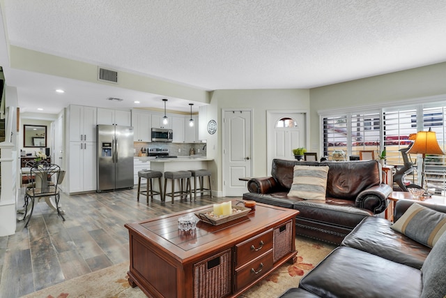 living room featuring a textured ceiling and light hardwood / wood-style floors