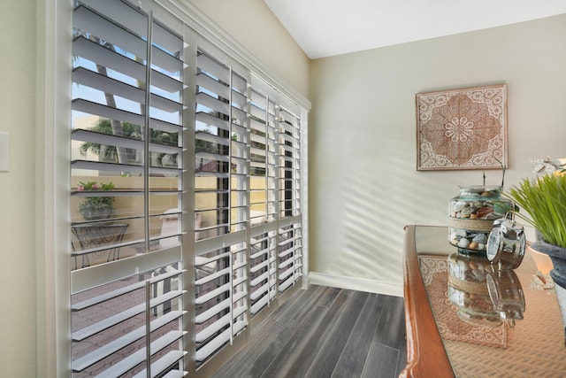 interior space featuring baseboards and dark wood-type flooring