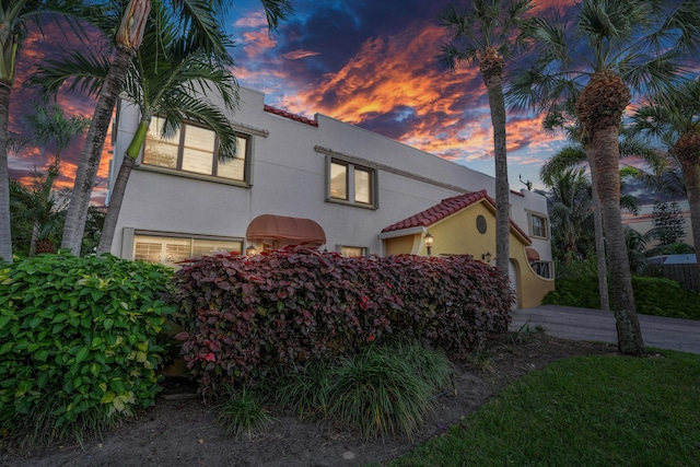 view of front of home with stucco siding, a garage, and a tiled roof