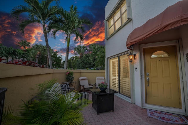 exterior entry at dusk featuring a patio