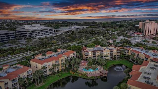 aerial view at dusk featuring a water view