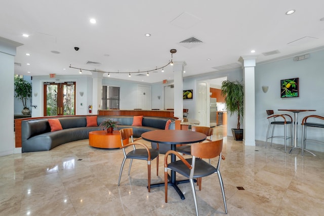 lobby with crown molding, decorative columns, and french doors