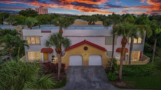 mediterranean / spanish-style home featuring stucco siding, driveway, and a garage