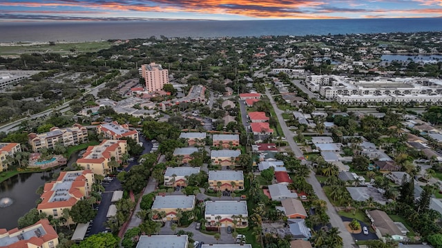 aerial view at dusk featuring a water view