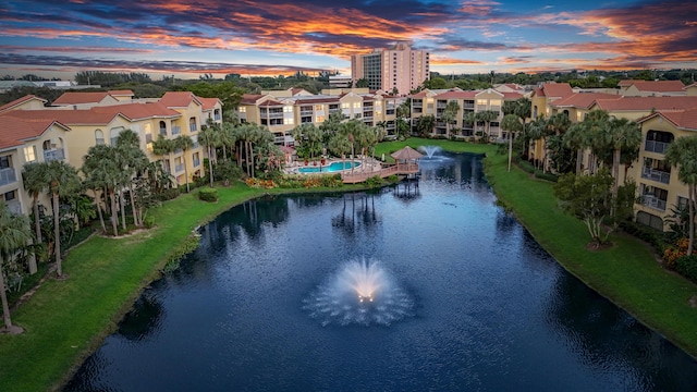 aerial view at dusk featuring a water view