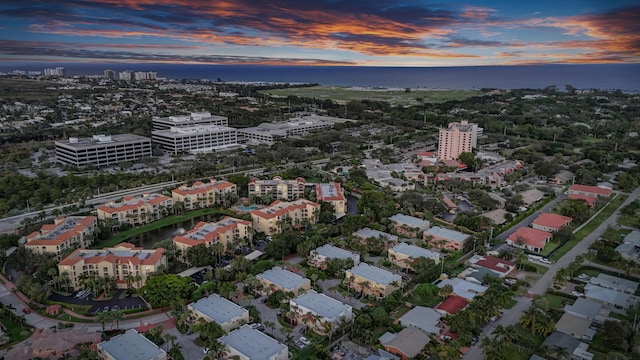 aerial view at dusk featuring a water view