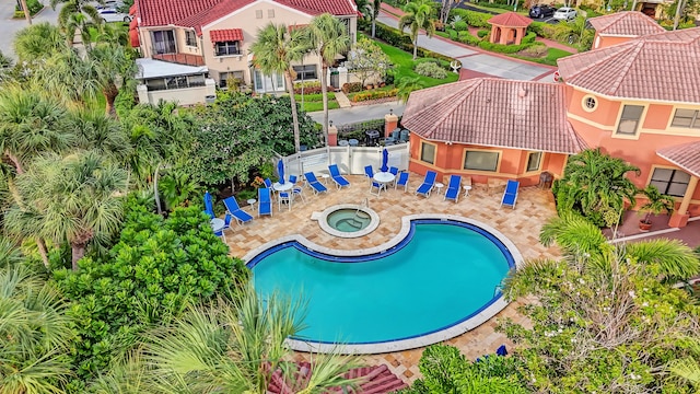 pool with fence, a community hot tub, and a patio area