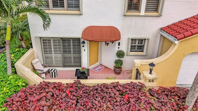 doorway to property featuring a tile roof and stucco siding