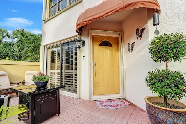 doorway to property featuring a patio and stucco siding