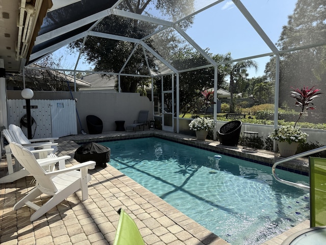 view of swimming pool featuring a lanai and a patio area