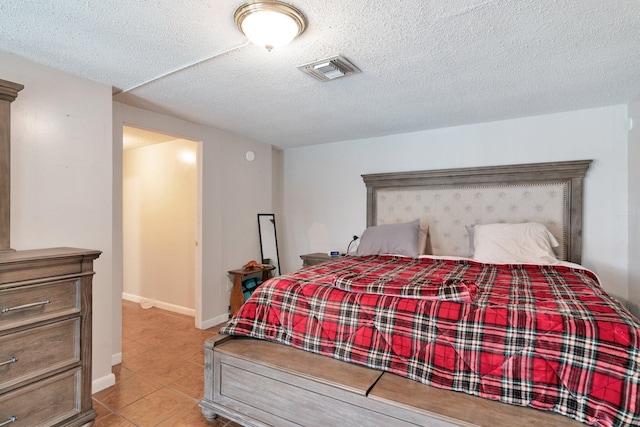 bedroom featuring light tile patterned flooring and a textured ceiling