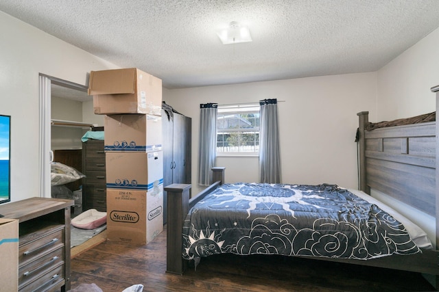 bedroom with a textured ceiling and dark hardwood / wood-style floors