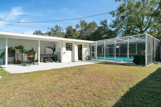 back of house featuring a lanai, a patio, and a lawn