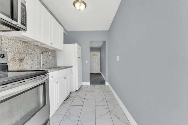 kitchen featuring sink, stainless steel appliances, white cabinetry, and backsplash