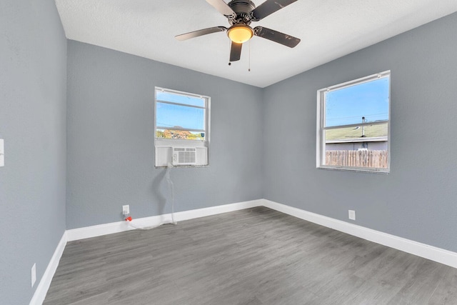 unfurnished room featuring cooling unit, hardwood / wood-style floors, and ceiling fan