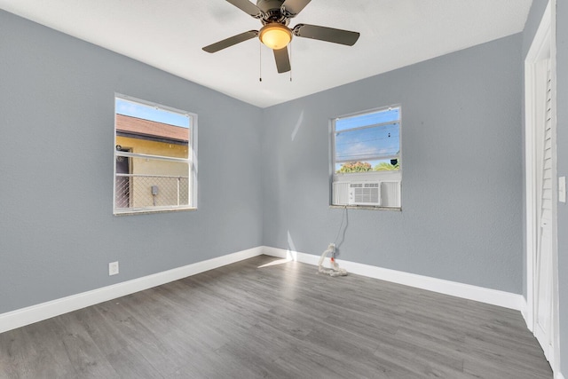 empty room with ceiling fan, cooling unit, and wood-type flooring