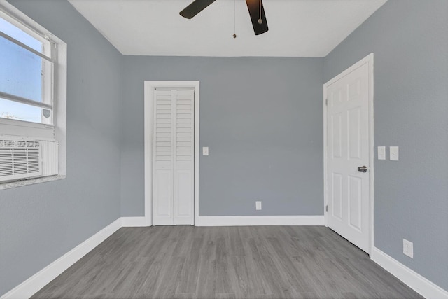 spare room with ceiling fan, cooling unit, and wood-type flooring