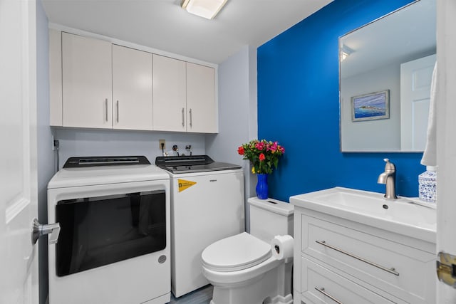 bathroom featuring sink, washing machine and dryer, and toilet