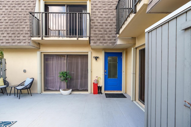 property entrance featuring a balcony and a patio area