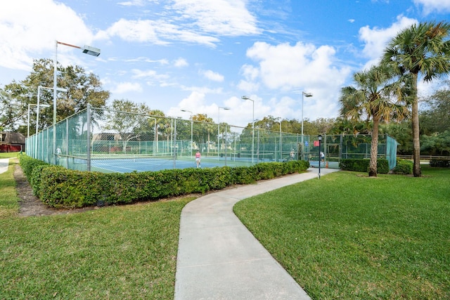 view of tennis court featuring a lawn