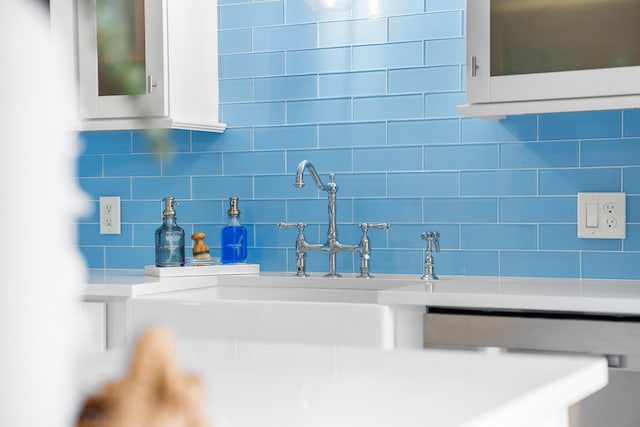 room details featuring white cabinets and backsplash