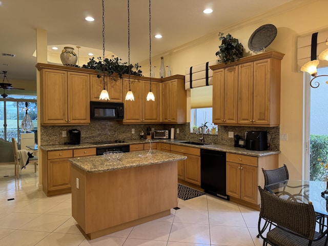 kitchen with black appliances, a center island, decorative light fixtures, sink, and stone counters