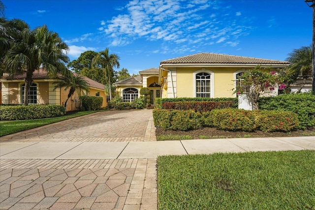 mediterranean / spanish-style home featuring a front yard