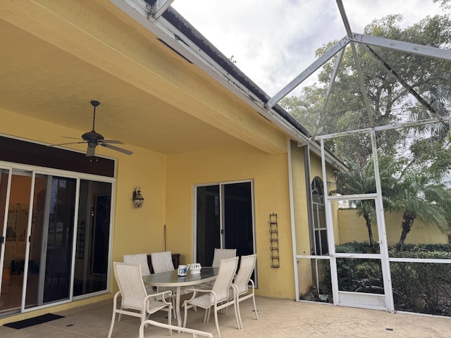 view of patio with glass enclosure and ceiling fan