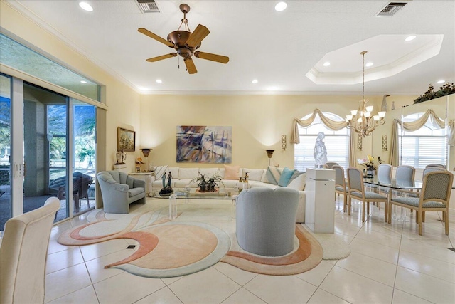 tiled living room with ceiling fan with notable chandelier, ornamental molding, and a raised ceiling