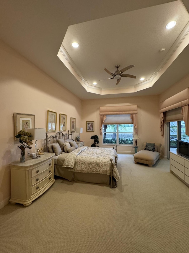 bedroom with a raised ceiling, ceiling fan, crown molding, and carpet floors