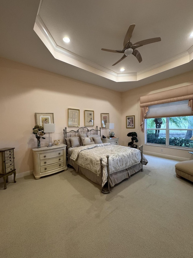 bedroom with light carpet, ceiling fan, ornamental molding, and a tray ceiling