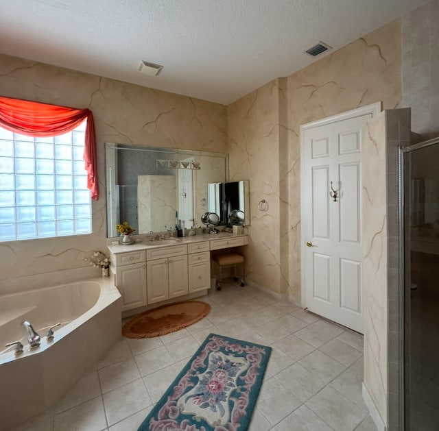 bathroom with vanity, tile patterned floors, plus walk in shower, and a textured ceiling