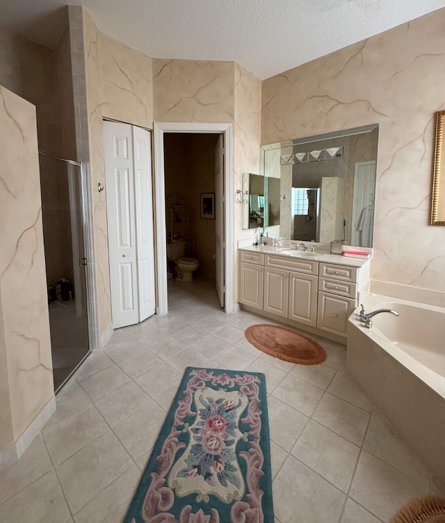 full bathroom featuring toilet, tile patterned floors, a textured ceiling, shower with separate bathtub, and vanity