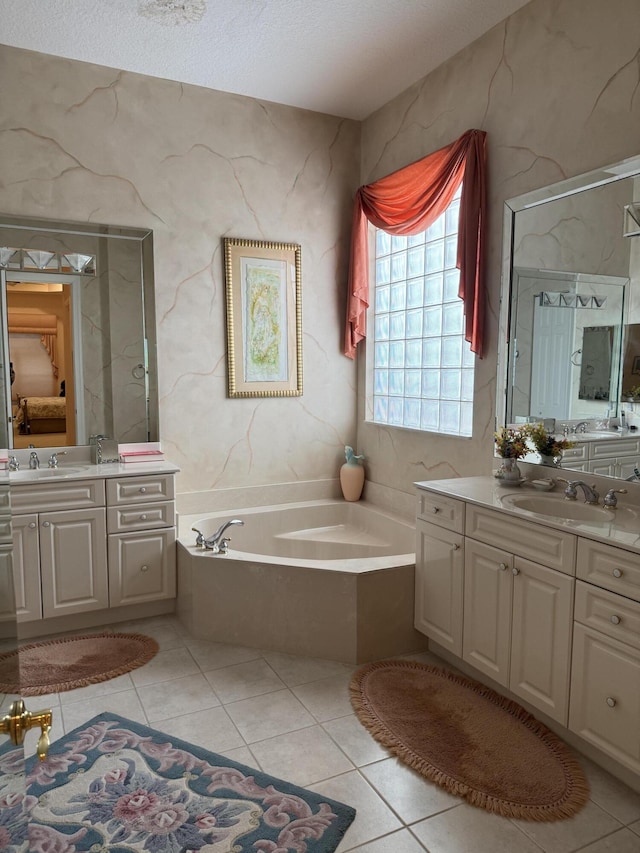 bathroom featuring a textured ceiling, vanity, a bathing tub, and tile patterned flooring