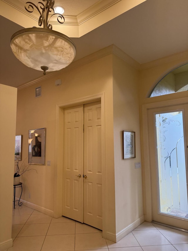 tiled entrance foyer featuring ornamental molding